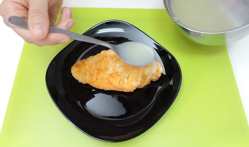 Añadiendo la salsa de limón sobre el pollo frito