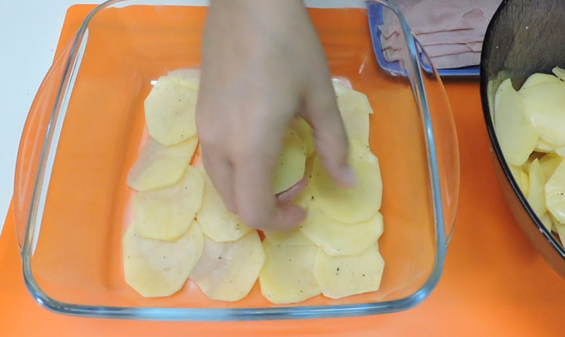 Poniendo rodajas de patata en la base