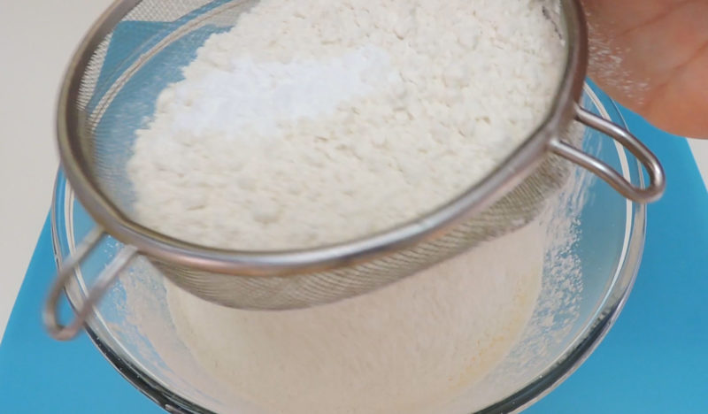 Tamizando la harina y la levadura química sobre la masa de bizcocho
