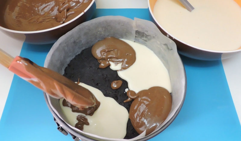 Repartiendo las cremas de queso y chocolate en el molde