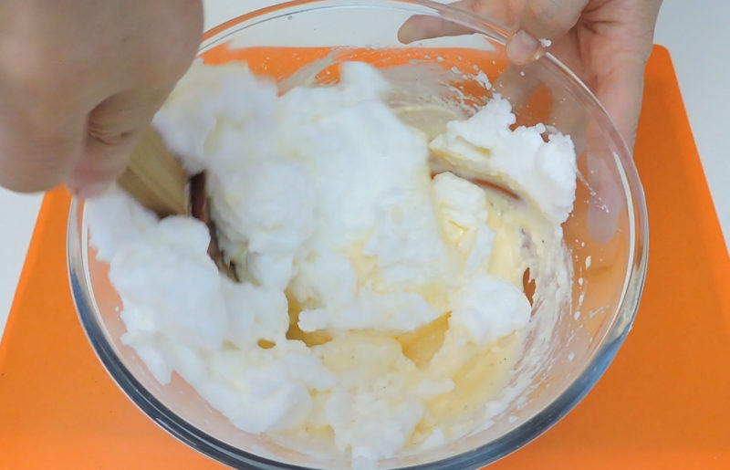 Incorporando las claras en la mezcla de yemas y queso