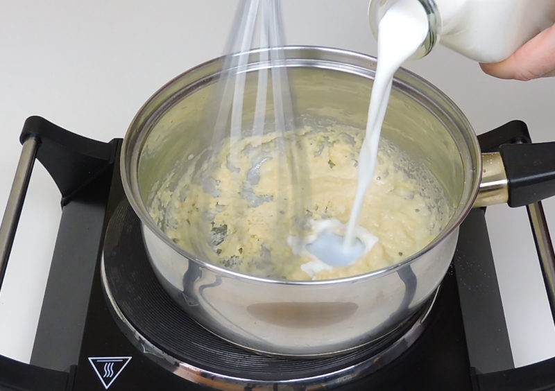 Añadiendo la leche a la mezcla de aceite, mantequilla y harina