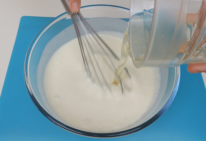 Vertiendo la gelatina líquida en la mezcla de yogur