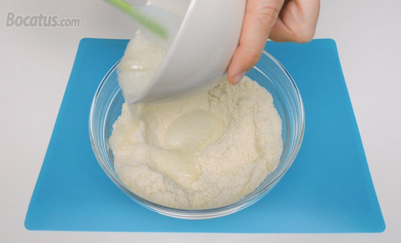 Añadiendo la clara batida a la mezcla de almendra y azúcar