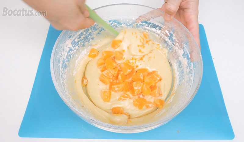 Integrando los trozos de mandarina y la ralladura en la masa de bizcocho