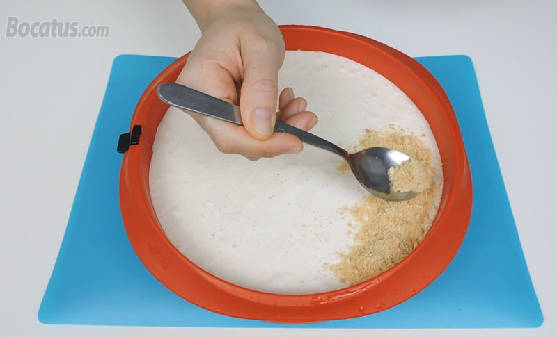 Cubriendo la superficie de la tarta con la galleta molida