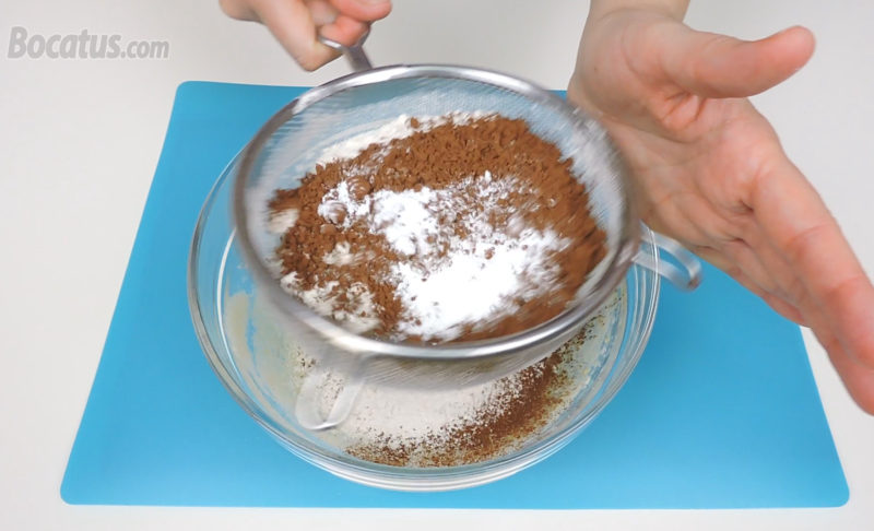 Tamizando la harina, el cacao y la levadura sobre la crema