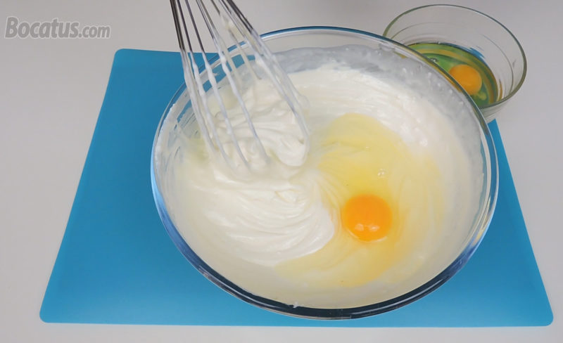 Integrando los huevos, de uno en uno, en la mezcla de queso