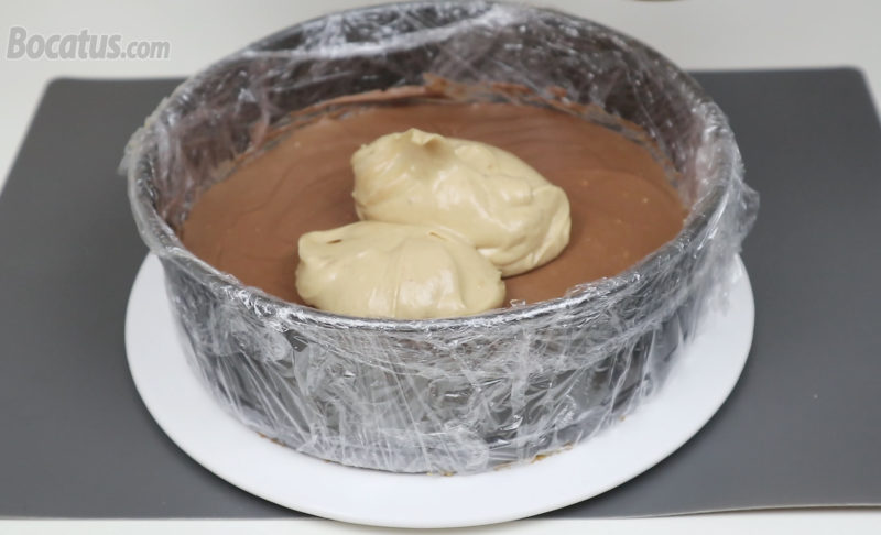 Añadiendo la mezcla de queso y crema de cacahuete sobre la capa de chocolate