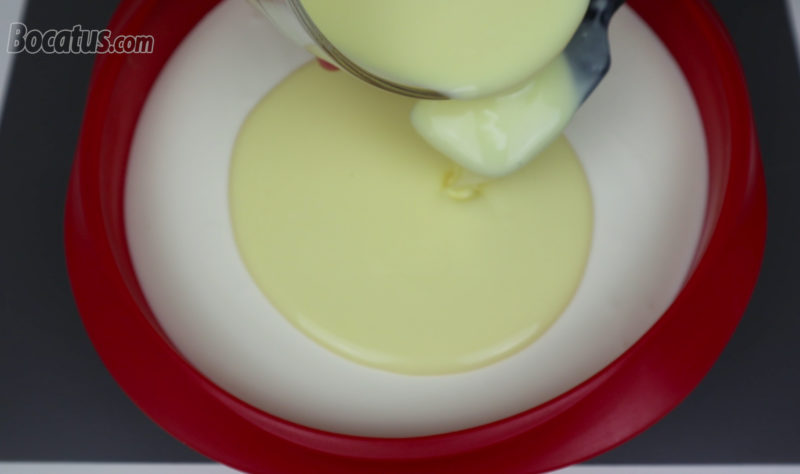 Vertiendo la cobertura de yogur en la superficie de la tarta