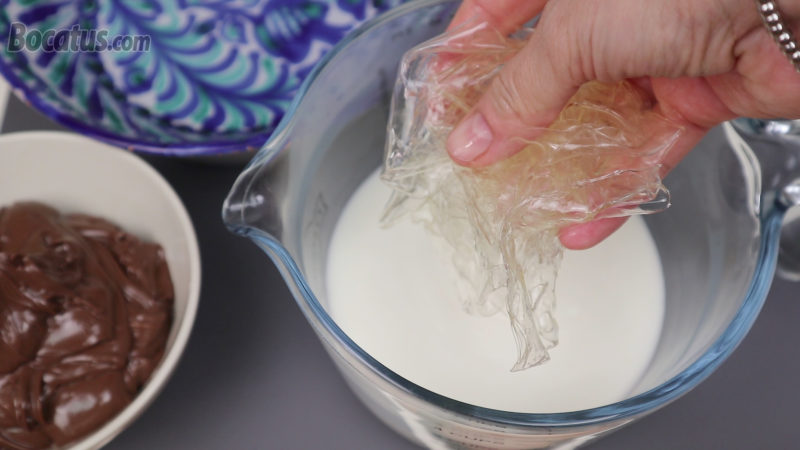 Añadiendo las hojas de gelatina hidratadas en la leche caliente