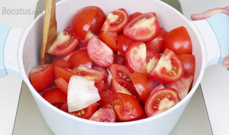 Friendo los tomates junto con los ajos y la cebolla