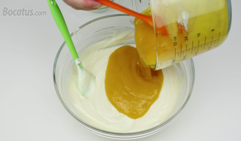 Añadiendo el puré de mango con gelatina a la mezcla de queso y chocolate