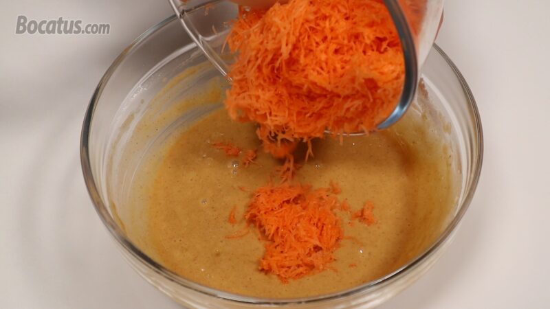 Incorporando la zanahoria rallada en la masa del bizcocho Incorporando la zanahoria rallada en la masa del bizcocho