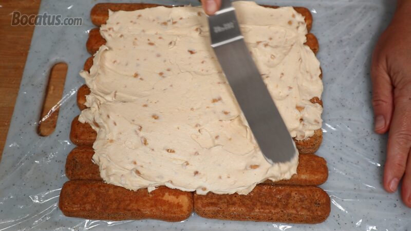 Extendiendo el relleno sobre la plancha de bizcochos Extendiendo el relleno sobre la plancha de bizcochos