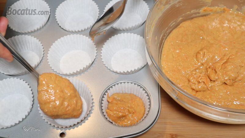 Distribuyendo la masa en el molde para magdalenas Distribuyendo la masa en el molde para magdalenas