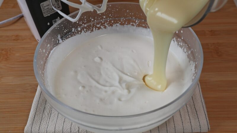 Añadiendo la leche condensada en la nata semimontada